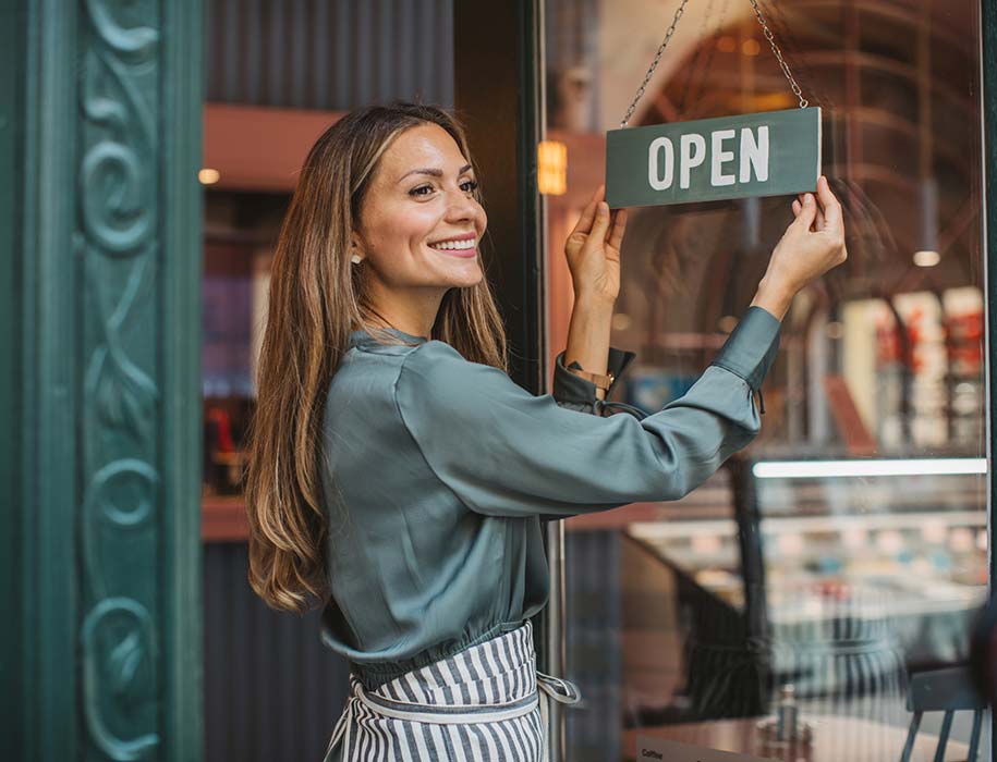 A lady opening her small business storefront
